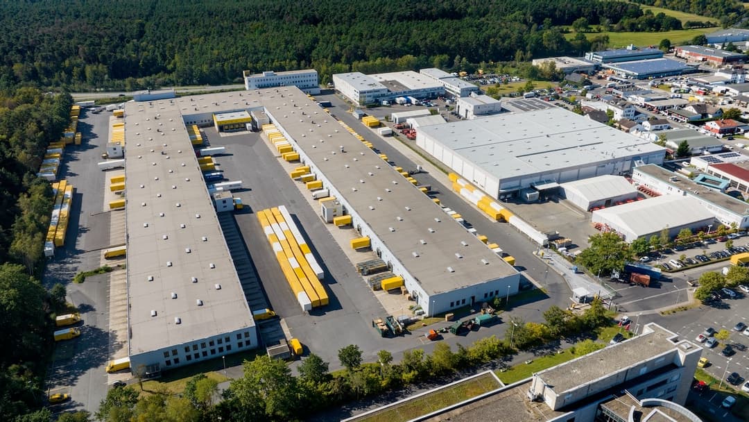 Vista aérea de un amplio estacionamiento y centro de distribución industrial, ideal para la instalación de sistemas de ventilación eficientes de Bioclimex.