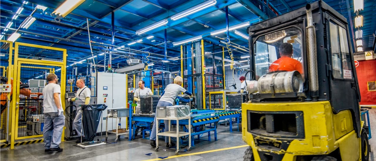 Línea de montaje industrial con trabajadores operando en un ambiente climatizado por Bioclimex