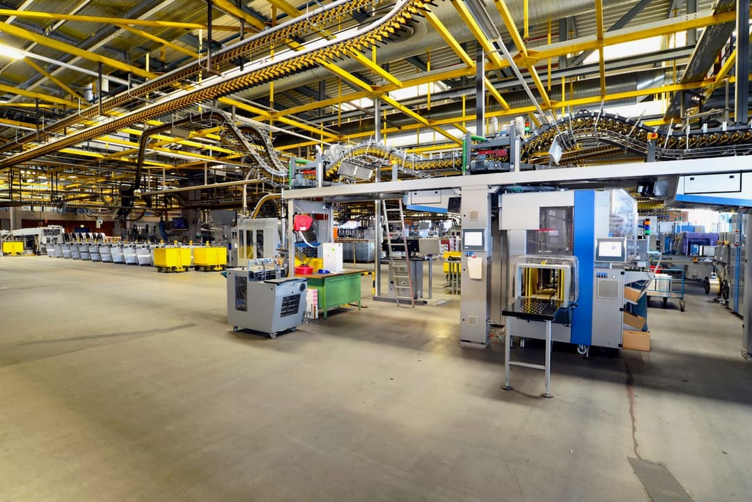Interior de una planta de ensamblaje con techos altos y líneas de producción, donde los sistemas de aire acondicionado de Bioclimex pueden mejorar la eficiencia y condiciones de trabajo.