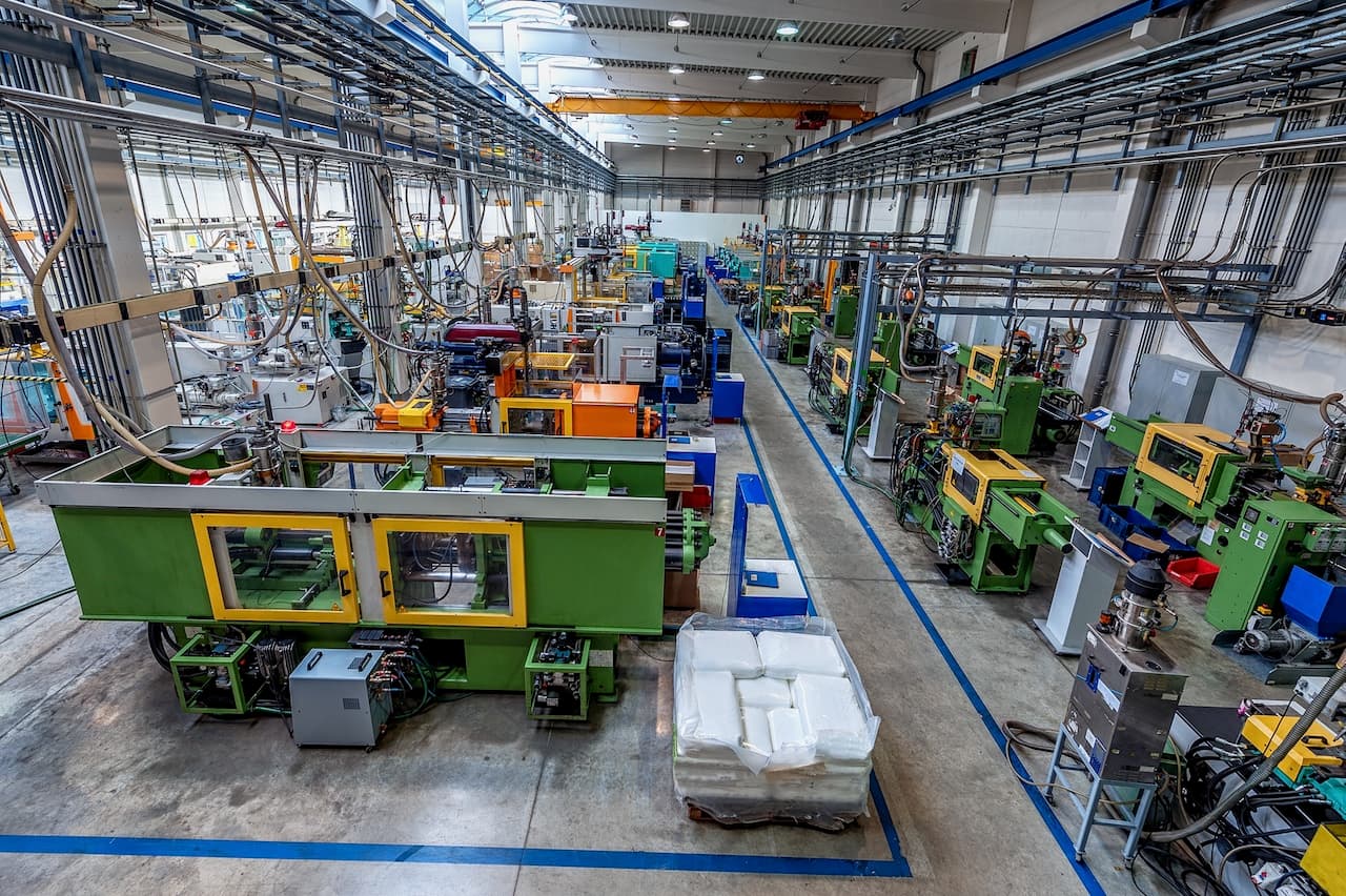 Interior de una planta de producción en México con maquinaria pesada y empleados, destacando los sistemas de aire acondicionado de Bioclimex en operación.