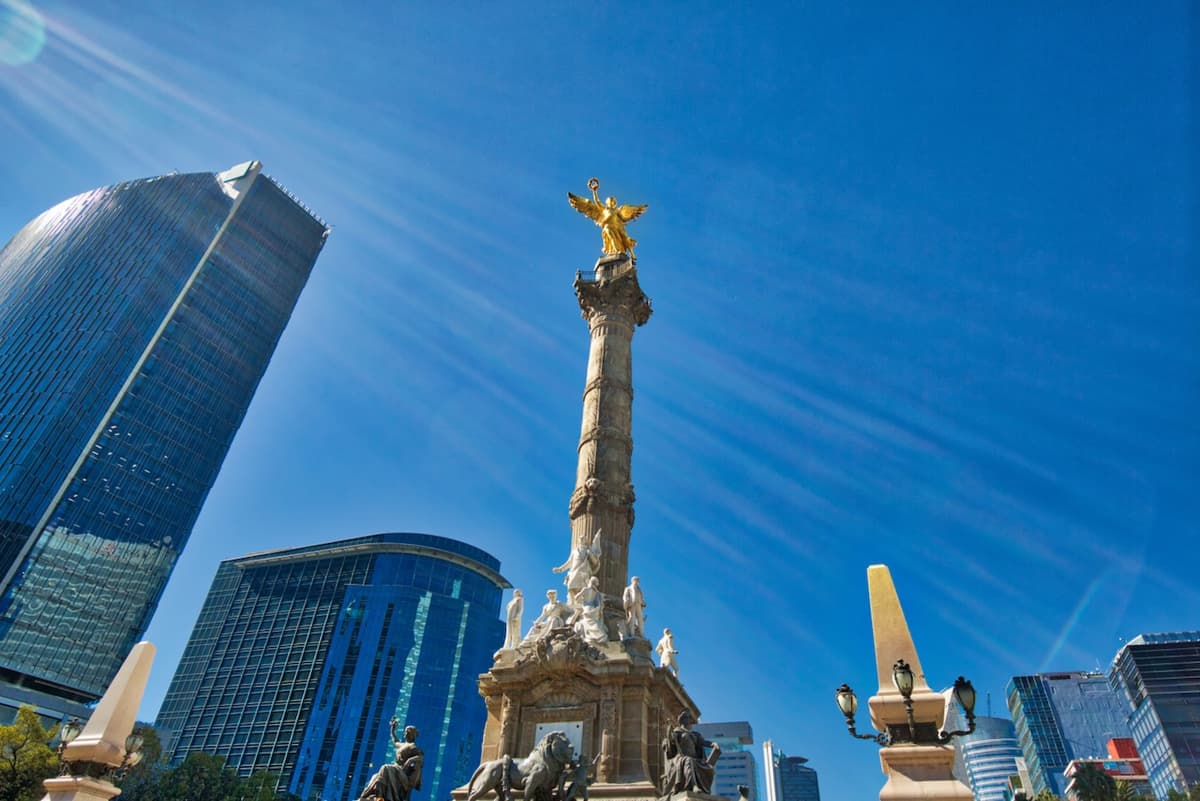 Vista del Ángel de la Independencia en la Ciudad de México, destacando los rascacielos modernos en el fondo, representando el alcance nacional de Bioclimex en soluciones de aire acondicionado industrial.