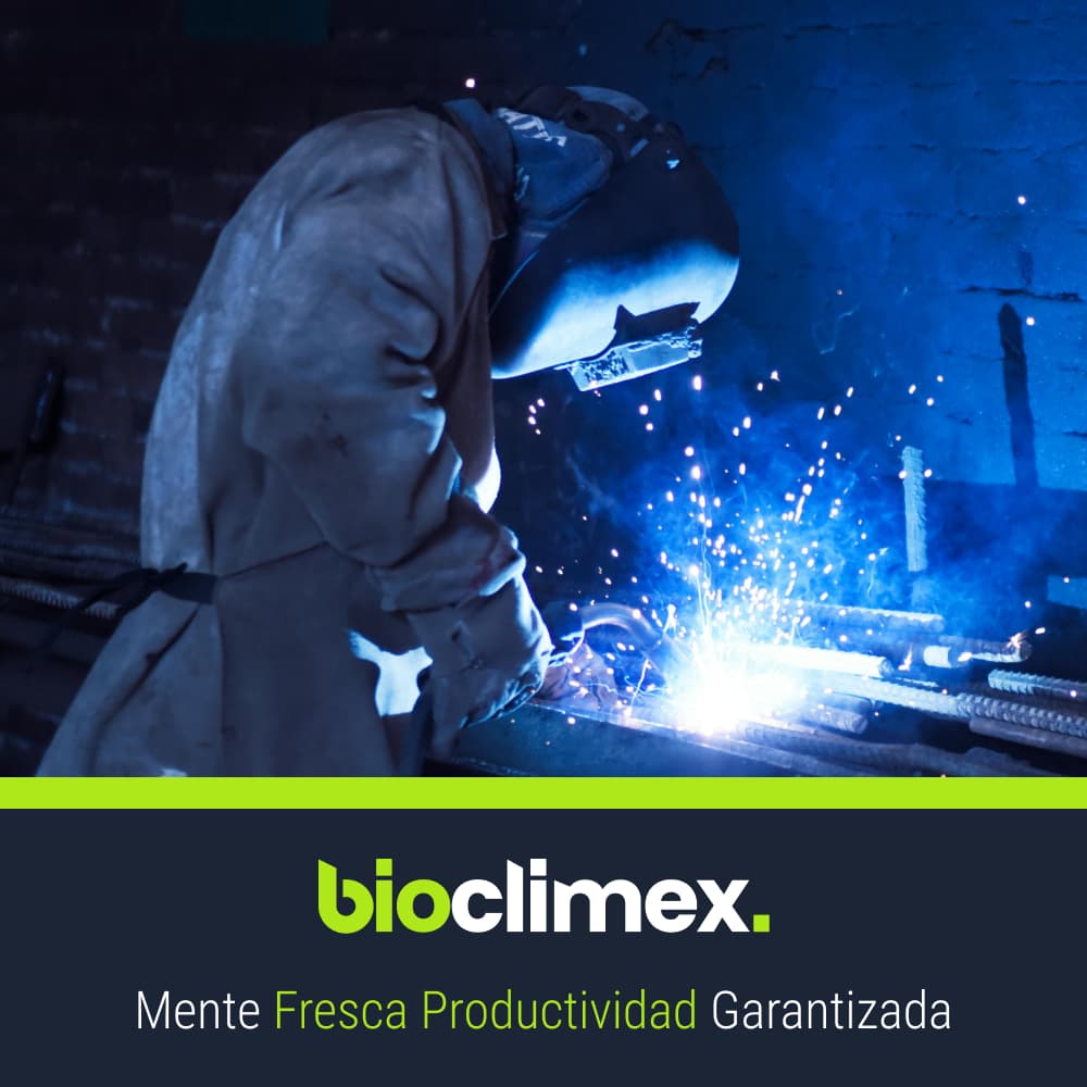 Soldador trabajando con chispas volando en un taller industrial, donde la ventilación adecuada de Bioclimex es crucial para la seguridad en México.