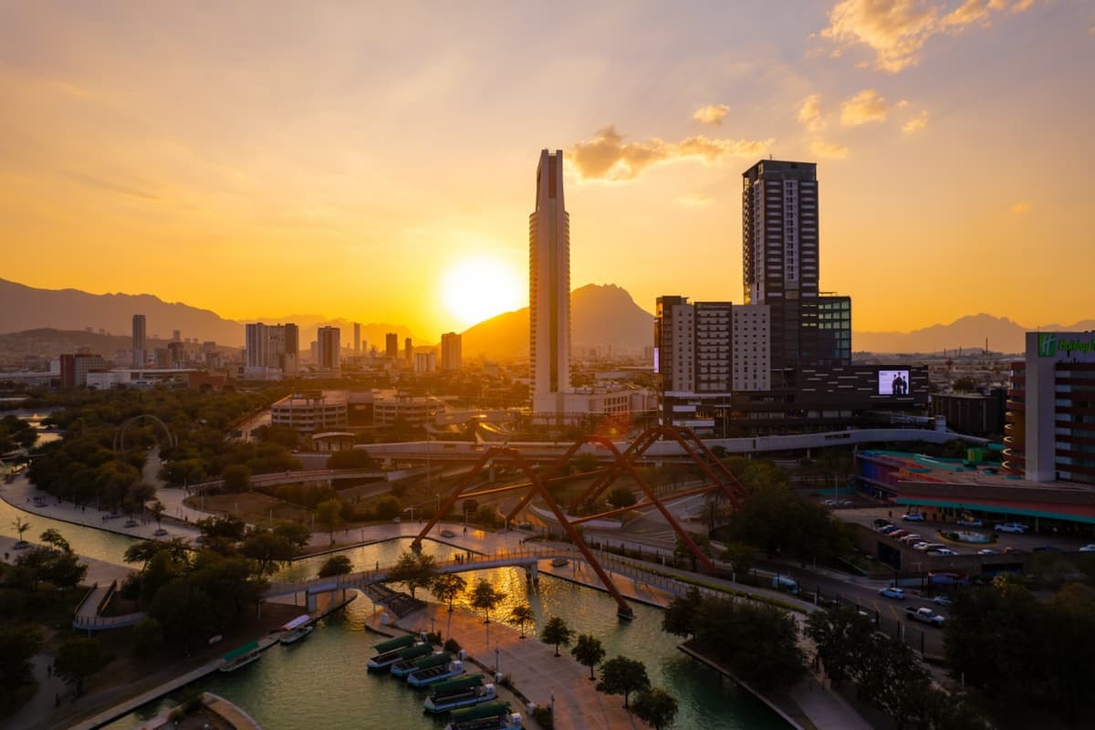 Vista del atardecer en Monterrey con la Torre Pabellón M, simbolizando la relación entre espacios urbanos y la necesidad de climatización eficiente en oficinas y edificios.
