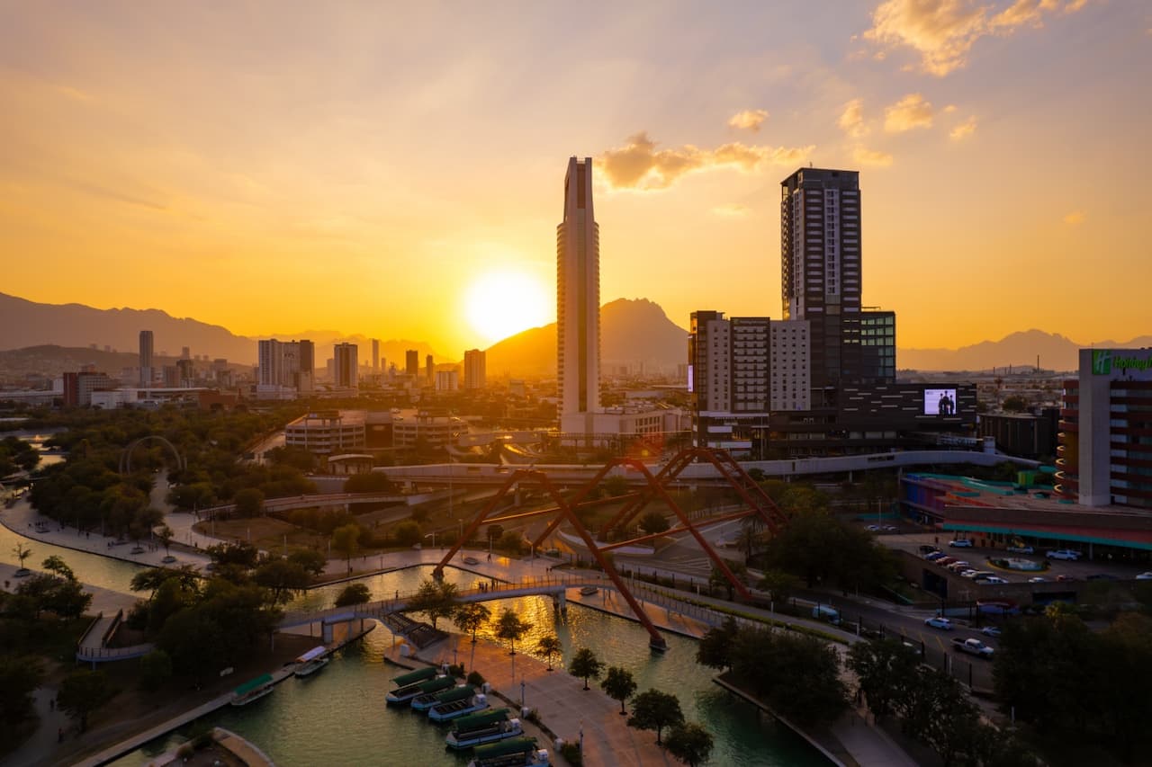 Vista del atardecer en Monterrey con la Torre Pabellón M, simbolizando la relación entre espacios urbanos y la necesidad de climatización eficiente en oficinas y edificios.